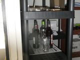 a black shelf with bottles on it in a room