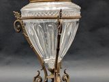 an antique silver and glass covered urn with a bird on top