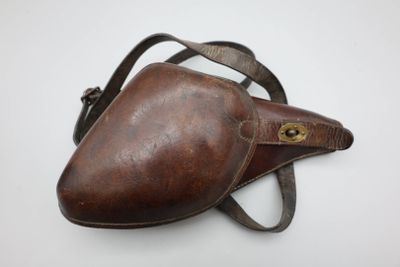 un vieux porte-monnaie en cuir marron muni d'un fermoir métallique, sur fond blanc