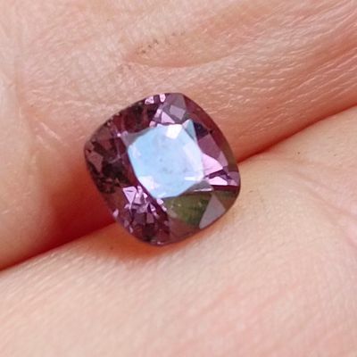quelqu'un tient une pierre précieuse violette dans la main