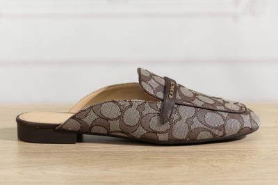 les chaussons marron et blancs sont posés sur une table en bois