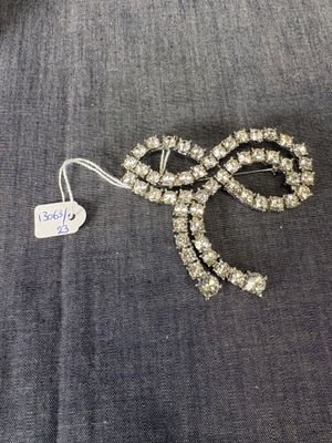 un gros plan d'une broche en forme de nœud sur laquelle est accrochée une étiquette de prix