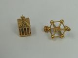 a close up of a pair of gold earrings on a white surface