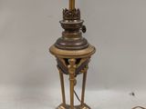 a brass table lamp with a glass shade on top of it