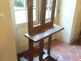 une chaise en bois placée devant une fenêtre dans une pièce