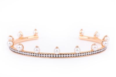 a close up of a gold bracelet with pearls and diamonds