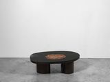 une table basse noire avec un piètement en bois et un plateau circulaire