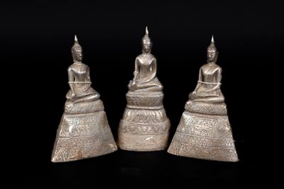 three silver figurines of buddhas sitting on top of each other