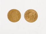 two gold coins on a white surface with a white background