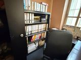 a desk with a chair in front of a book shelf