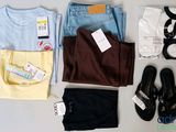 a lot of clothes and shoes laid out on a table