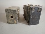 two old cameras sitting next to each other on a table
