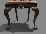 a chair that is sitting on a table with a clock on it