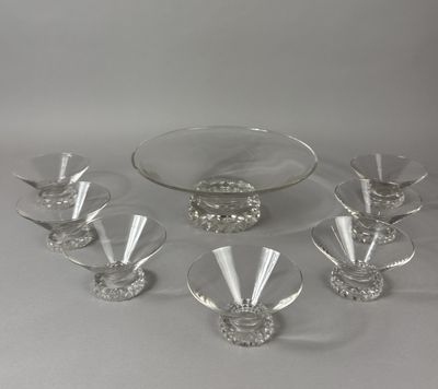 several glasses and a bowl on a table on a white surface