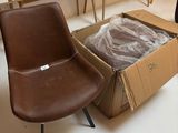 deux chaises et une table dans une pièce où se trouve un carton posé par terre