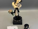 an image of a figurine of a dog with a flower in its hand