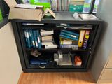 a book shelf with many books on it in a room