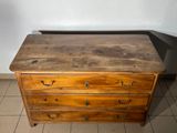 a wooden chest of drawers on a tiled floor