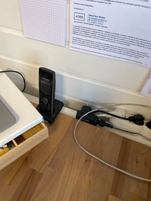 un micro-ondes posé par terre à côté d'un téléphone