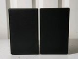 une paire d'enceintes noires posées l'une à côté de l'autre sur une table