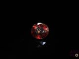 a close up of a red diamond on a black surface