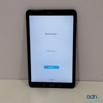 une tablette posée sur une table, avec un bouton bleu à l'écran
