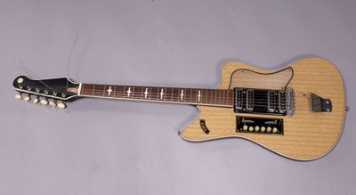 an electric guitar sitting on top of a table next to a wall