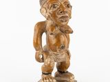 l'image d'une statue en bois représentant un homme avec un chapeau sur la tête
