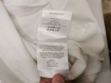 someone is holding a white shirt with a price tag on it
