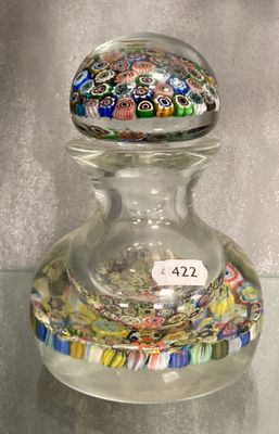 un bocal en verre muni d'un couvercle en verre, posé sur une table en verre