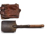 an old pair of shovels and a leather case on a white surface