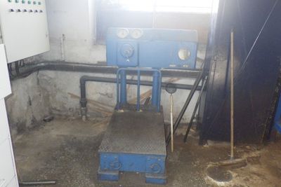 une machine bleue dans une pièce sale avec une fenêtre