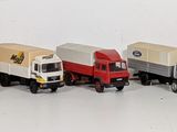 several toy trucks are lined up in a row on a white surface