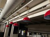 several red lamps hanging from the ceiling of a restaurant