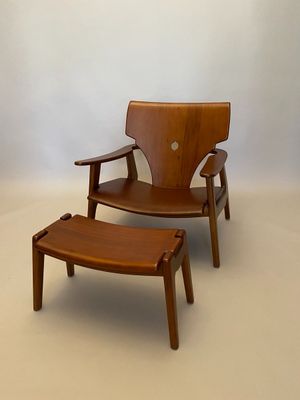 an image of a wooden chair and foot stool in a white room