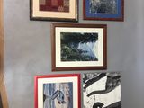 many pictures hanging on the wall of this room