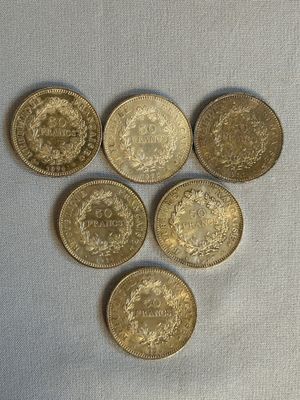 six pièces de monnaie britanniques disposées en forme de cœur sur un fond blanc