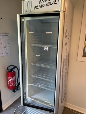 a refrigerator that is sitting in the corner of a room