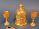 three pieces of gold colored glass sitting on top of a blue surface