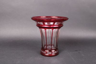a red glass vase sitting on a gray surface