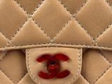a close up of a chanel bag with a red handle