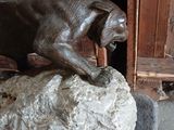 a statue of a dog that is on a rock