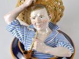 une figurine représentant un homme avec un panier sur la tête