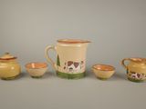 a pitcher, cups, and a jug sitting on a table