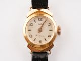 a gold wrist watch with a white face on a black strap