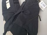 men ' s black pants with zippers and pockets on a white surface