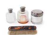 a brush, comb, and bottle of liquid on a white surface