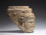 an image of a stone vase with a ram head on it