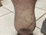 a glass vase sitting on the floor on the floor