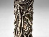 un gros plan d'un vase en argent orné d'un serpent